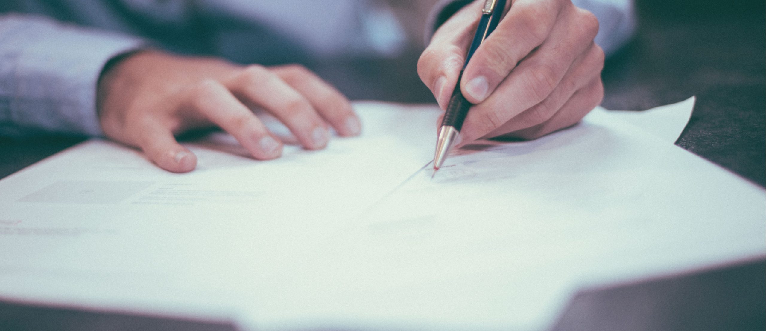 A person signing a document.